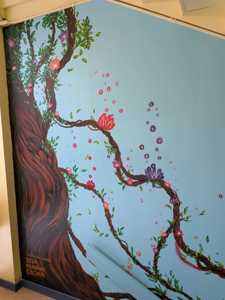 Murale « L’arbre du savoir » : un arbre en fleurs dont les branches portent des lettres