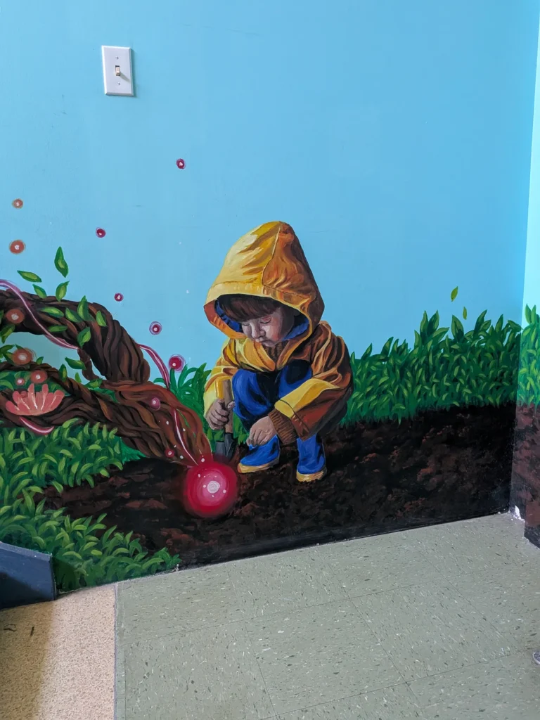Murale : un enfant en imperméable jaune déterre une graine lumineuse